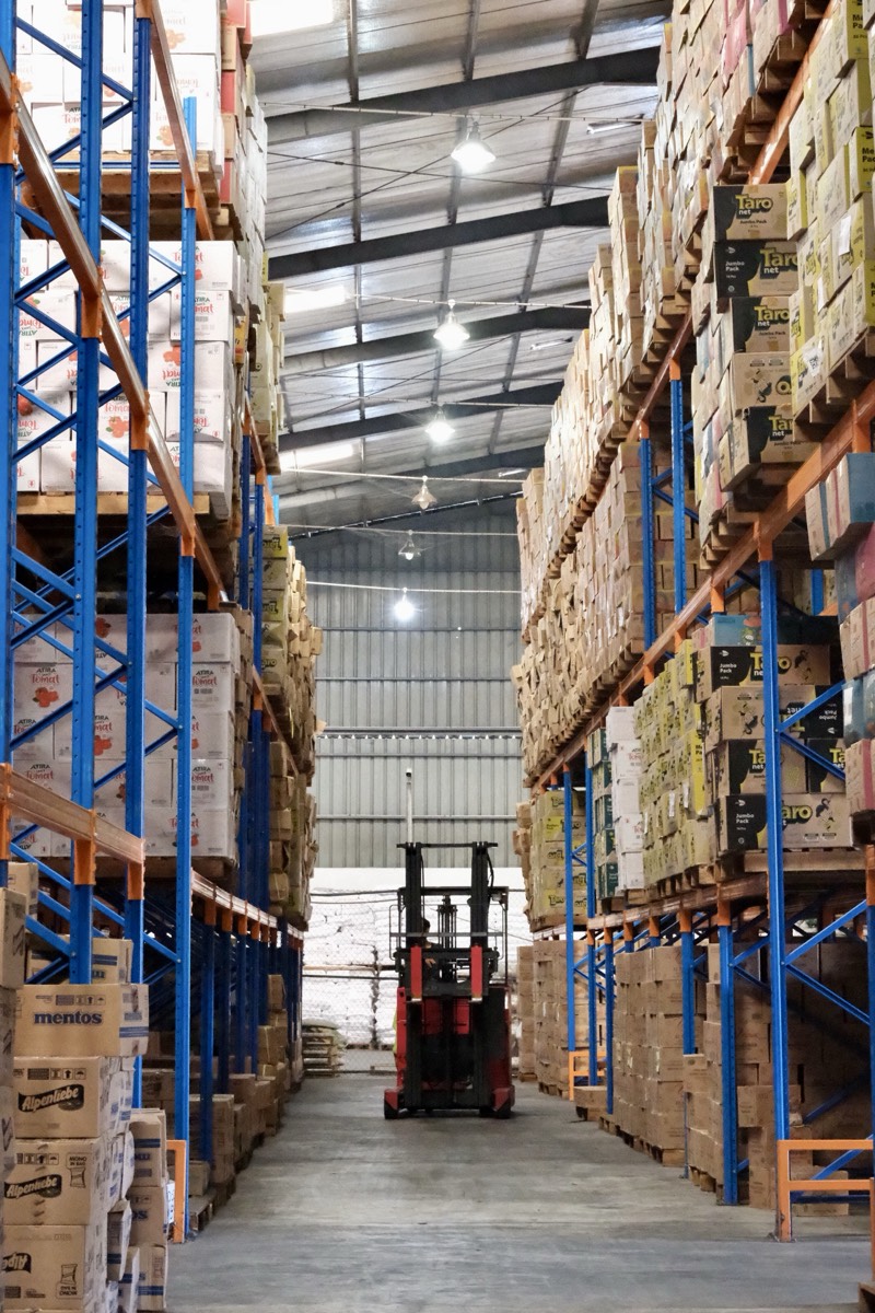 Forklift elektrik di lorong gudang AMD